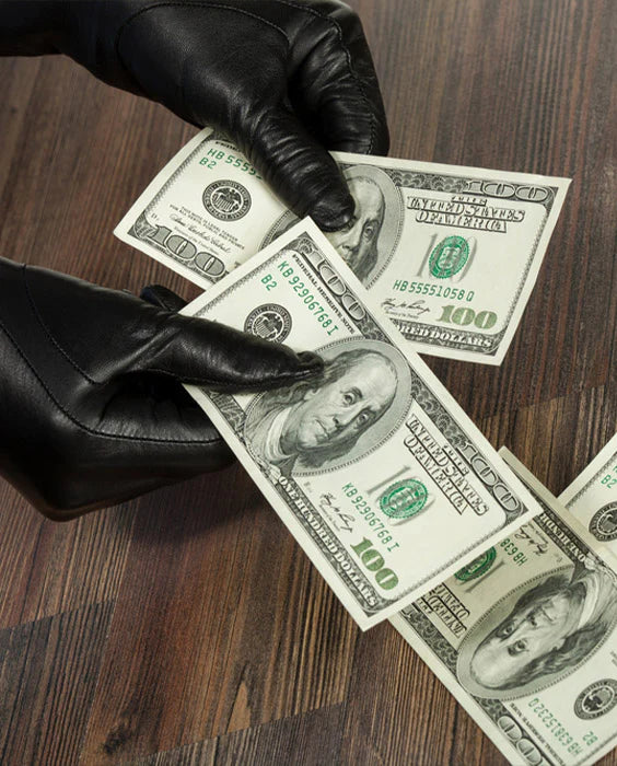 A man wearing black leather gloves from hugger gloves, counts cash while running his daily errands.